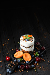 Homemade layered dessert with fresh apricot, blueberry, cherry, cream cheese or yogurt, granola.