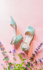 Fashion - summer footwear for woman. Pastel mint green sandals shoes and meadow flowers on pink