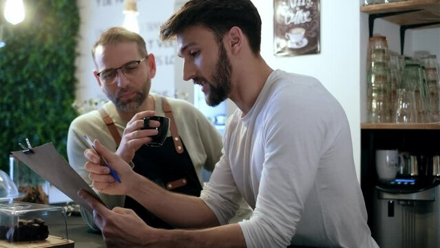 Video of couple owners bakery working while analyzing report for order delivery with digital tablet in a healthy pastry shop. - Powered by Adobe