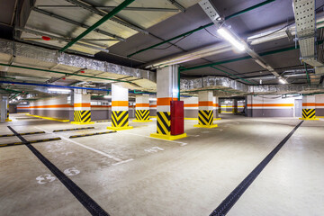 view of new empty underground parking with concrete columns and nobody inside