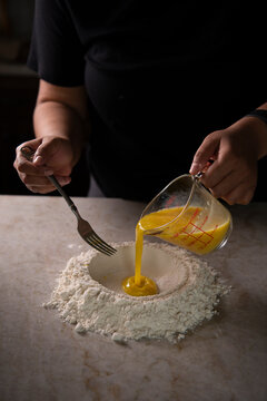 Pouring egg mixture to flour 