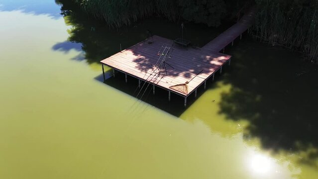 Carpfishing swim with rods on a dorpod and a net. Drone circle video footage