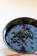 Dried mun mushrooms, Chinese traditional medicine and cuisine. Fungi ingredients in plate on beige background