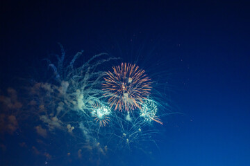 Obraz premium Firework over the blue sky at night, white, and green. Amateur photo. Noise. Grain.