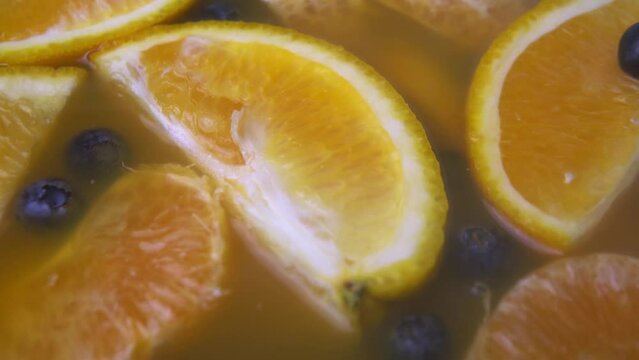 Alcoholic beverage with adding fume. Orange slices and blueberry.
