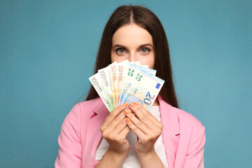 young woman holding euro bills near her face
