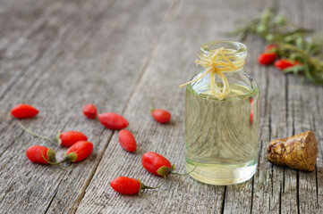 Glass bottle of goji berry oil with fresh goji berries, Lycium barbarum