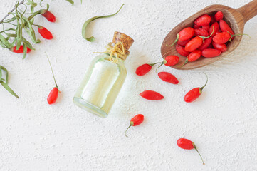Glass bottle of goji berry oil with fresh goji berries, Lycium barbarum