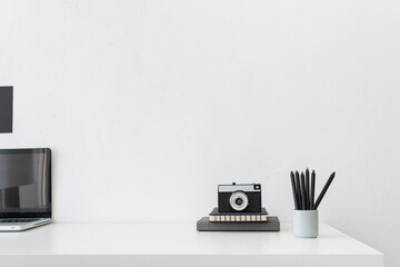 Home office, creative desk with office supplies and white wall..