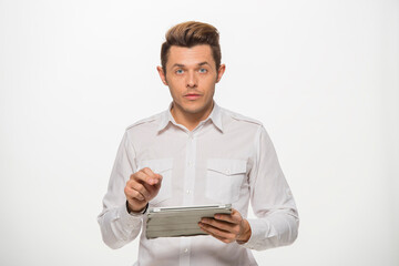 a man in a white shirt uses a tablet on a white isolated background.close-up portrait of a man with a tablet emotionally