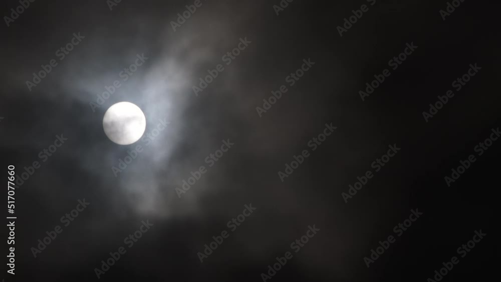 Sticker night sky is illuminated by full moon shining through dark clouds which take over turning sky black.