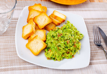 Traditional authentic Mexican guacamole of ripe avocados, onion, tomatoes, cilantro, jalapeno...