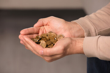 Closeup view of man holding coins indoors