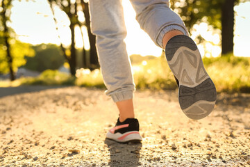 Woman running on pathway outdoors in morning, closeup
