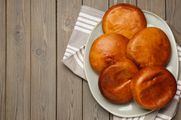 Delicious baked patties on wooden table, top view. Space for text