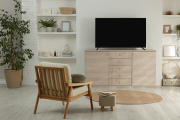 Stylish wide TV set on wooden cabinet in room