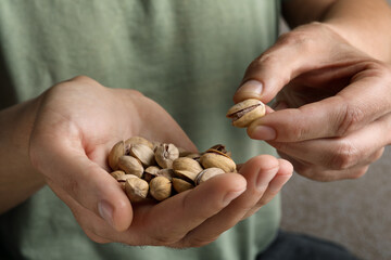 Woman holding tasty roasted pistachio nuts, closeup
