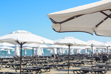 Fototapeta na wymiar Beautiful white beach umbrella at resort, closeup. Space for text