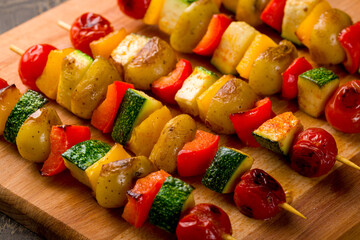 grilled vegetables skewers on board on dark brown table, canapes