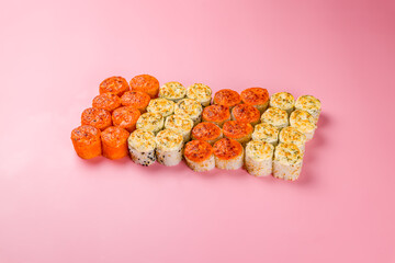 set of different rolls and sushi on pink background