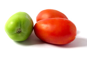 Two seedling tomatoes with one more green tomato on a white background