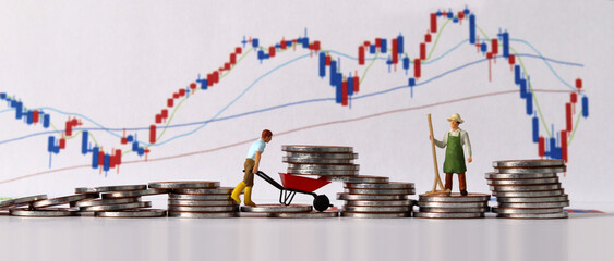 Concept of successful investment and management. Business concept with pile of coins and miniature people and graph.
