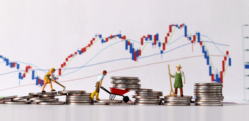 Concept of successful investment and management. Business concept with pile of coins and miniature people and graph.
