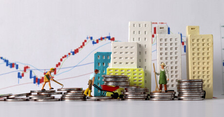 The concept of real estate investment. Business concept with miniature people and coins and graph.
