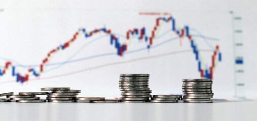 The concept of stock investment. Business concept with pile of coins and graph.
