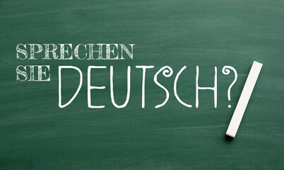 Text SPRECHEN SIE DEUTSCH? (DO YOU SPEAK GERMAN?) and chalk on blackboard