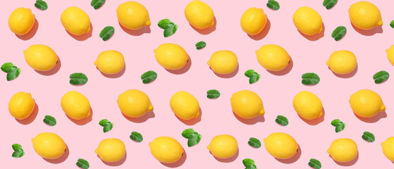 Many ripe lemons and mint leaves on pink background. Pattern for design