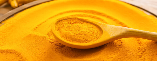 Plate and spoon with aromatic turmeric, closeup