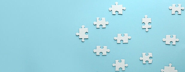 Pieces of jigsaw puzzle on light blue background with space for text
