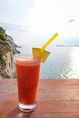 Glass of fresh tropical cocktail on table at sea resort