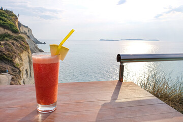 Glass of fresh tropical cocktail on table at sea resort