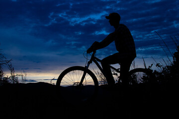 Obraz premium Silhouette of boy on mountain bike