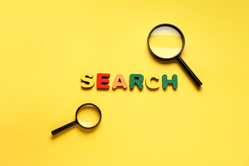 Magnifying glass and word SEARCH on yellow background