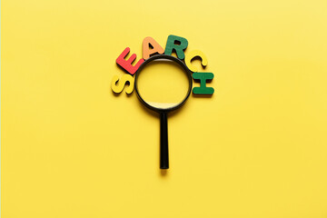 Magnifying glass and word SEARCH on yellow background