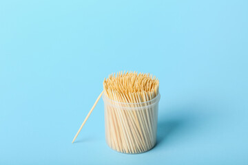 Plastic holder with toothpicks on blue background