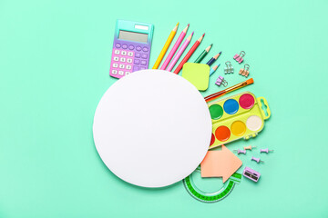 Composition with blank card and different stationery on color background