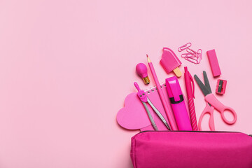 Pencil case with stationery supplies on pink background