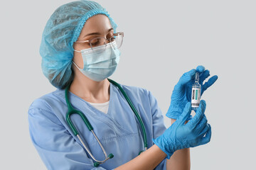 Female doctor with monkeypox vaccine on light background