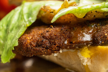 fried egg beef or chicken milanese in breadcrumbs with lettuce and tomato on a dark background