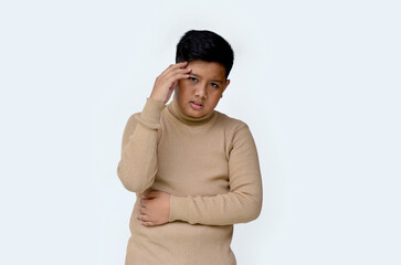 handsome asian boy with headache expression wearing sweater, isolated at white background