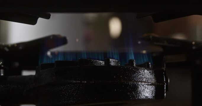 Wide super close up of a lit camp stove where a pan is placed which creates a fireball, 4k DCI, 240fps, super slow motion, low angle