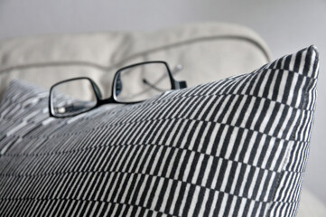 A glasses on the corner of sofa