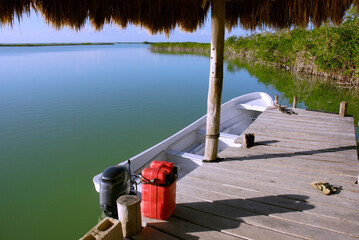 Boat at a small wooden pier on a lagoon in Sian Ka'an biosphere reserve, Mexico