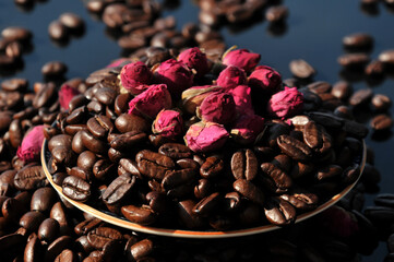 Coffee beans and preserved rose buds for tea drink in sunset