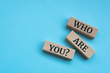 Who are you question words on wooden blocks on blue background.