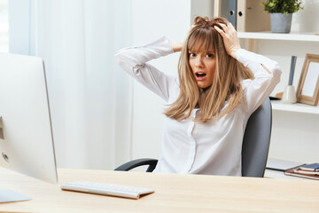 Shocked adorable blonde businesswoman typing answer for client look at camera touch head sitting at workplace in modern office. Unhappy employee work on computer online in support service. Copy space